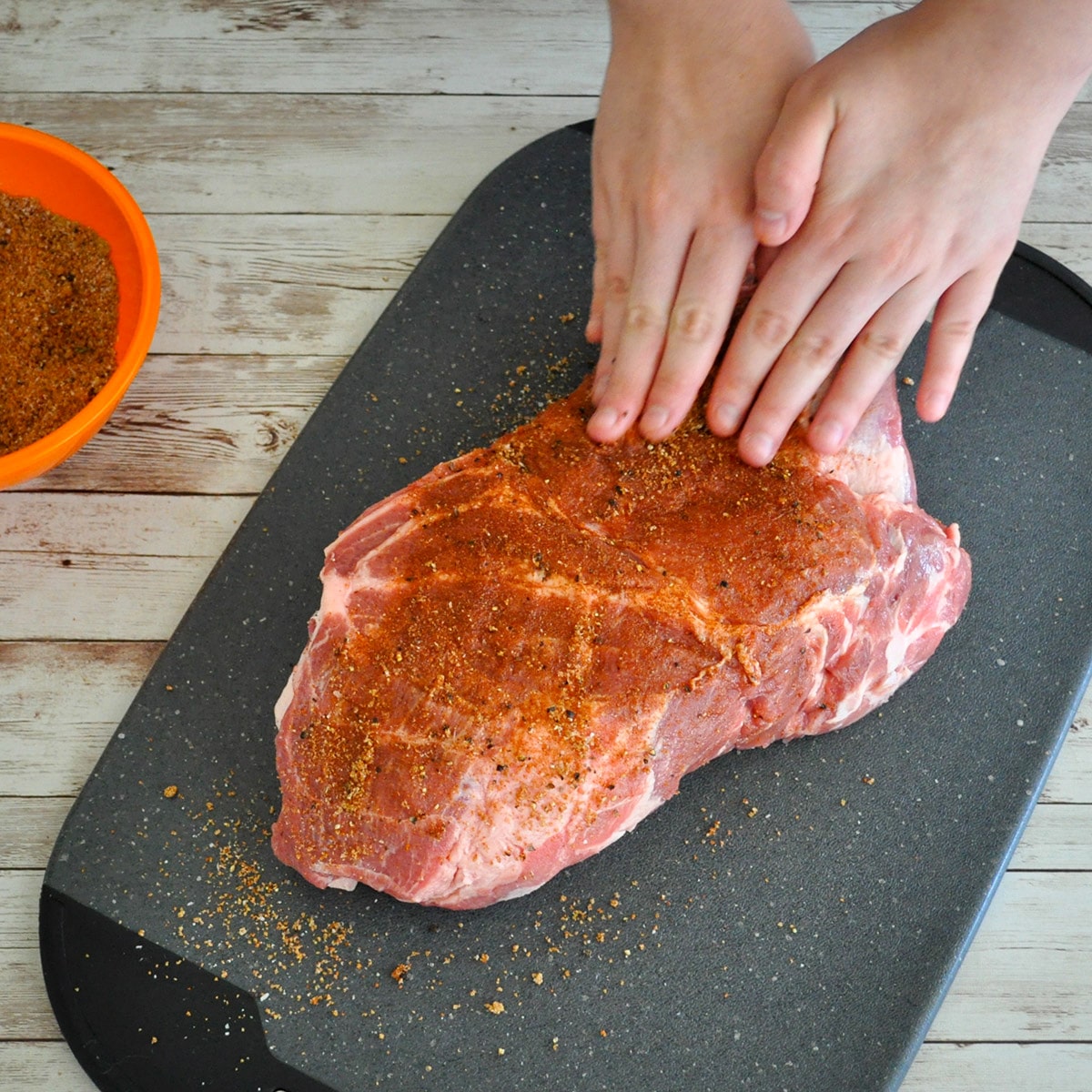 seasoning being rubbed into a pork shoulder