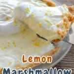 A delightful no-bake lemon pie graces the wooden table, its marshmallow filling crowned with whipped topping and a sprinkle of lemon zest.
