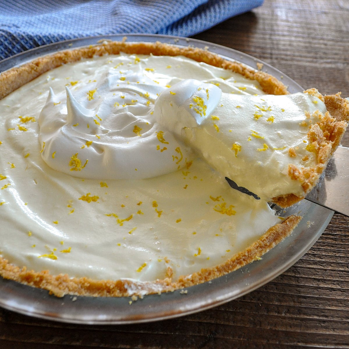 A slice of lemon pie being lifted from a whole lemon pie