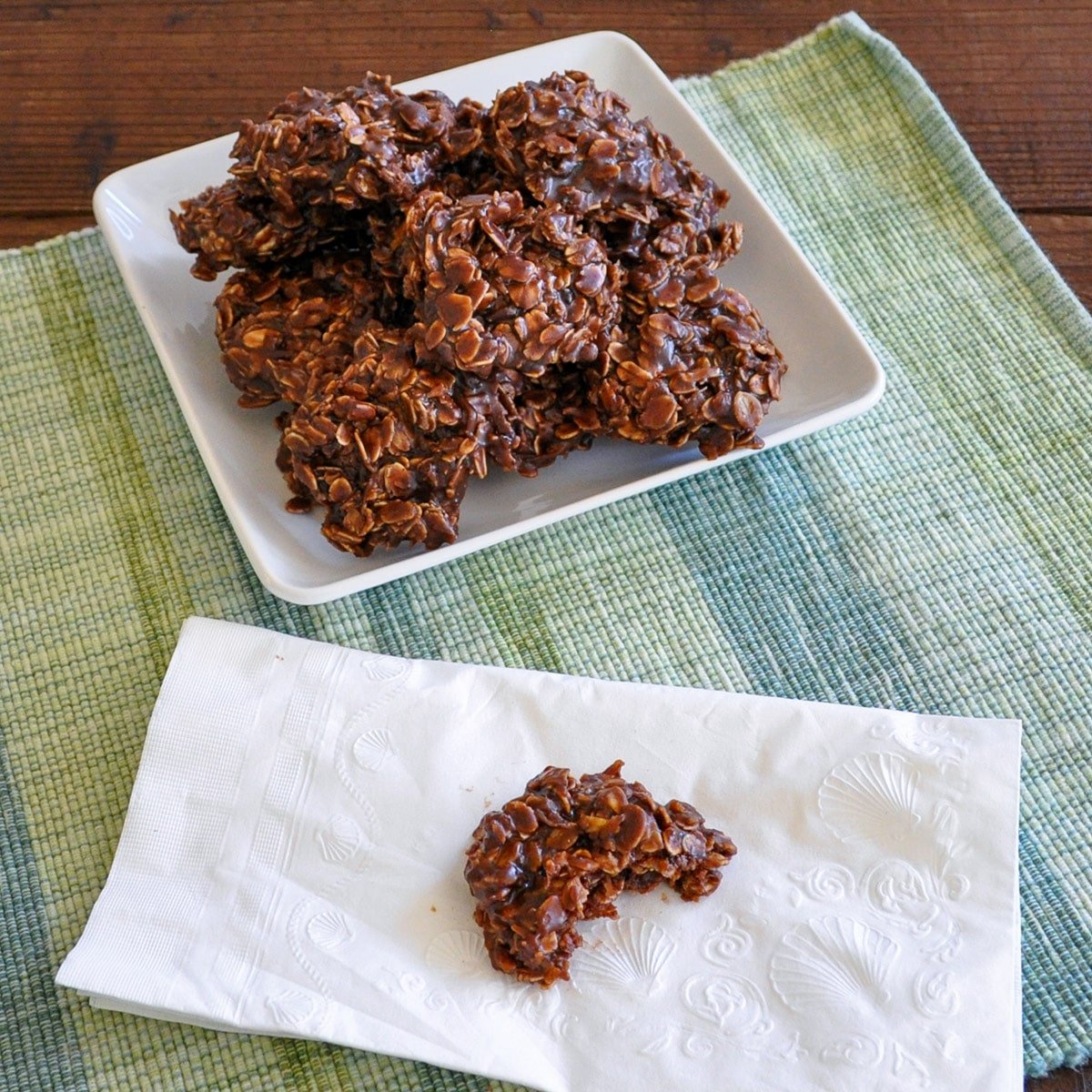 chocolate no bake cookies on a plate next to a napkin with a half eaten cookie