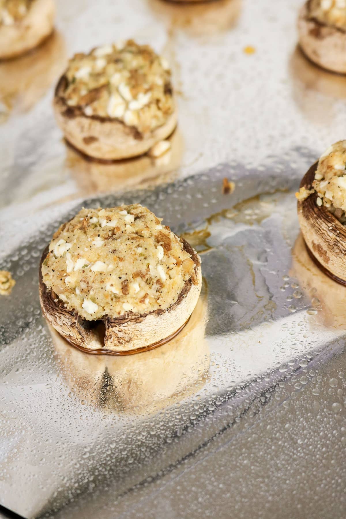 Easy Stuffed Mushrooms with breadcrumbs and cheese are arranged on a foil-lined baking sheet, ready to be baked to golden perfection.