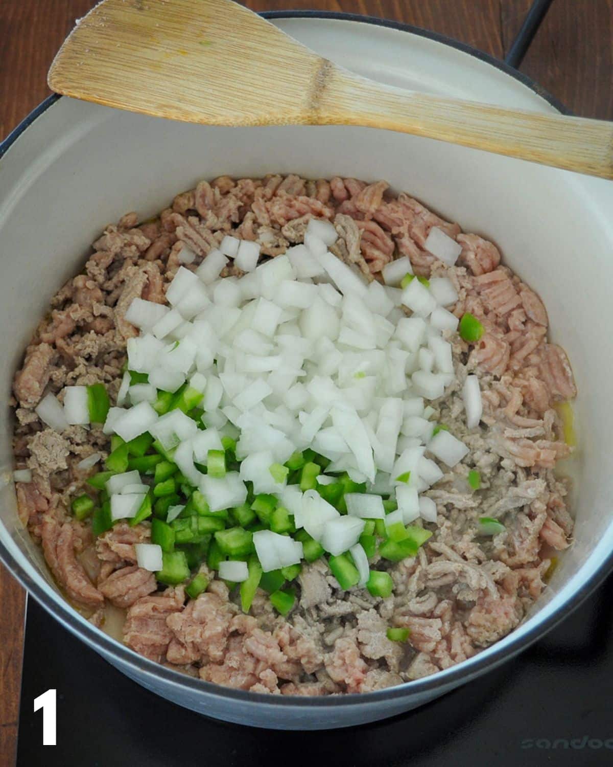 Ground turkey with onion and bell pepper cooking in a large pan. 