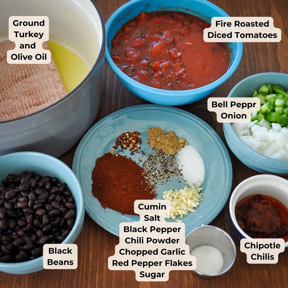 Bowls hold ground turkey, beans, diced tomatoes, vegetables, and spices prepped for making a flavorful Turkey Chipotle Chili.
