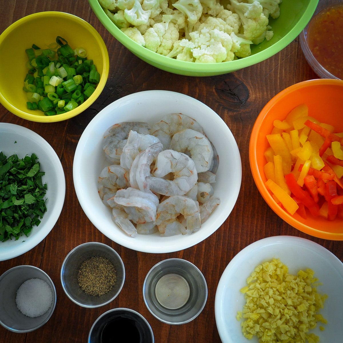 Bowls with ingredients for shrimp and cauliflower stir fry