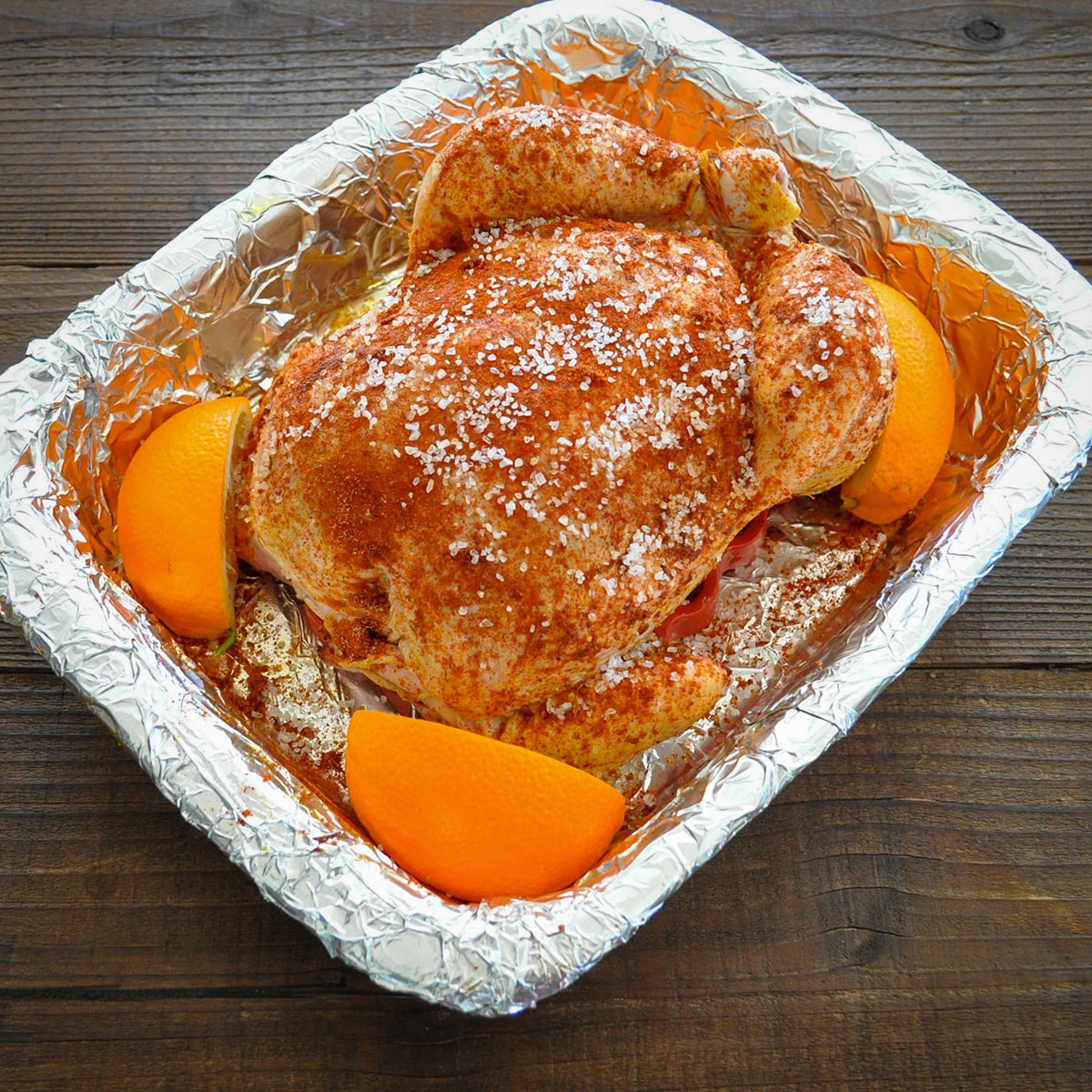 raw chicken in a baking dish with oranges