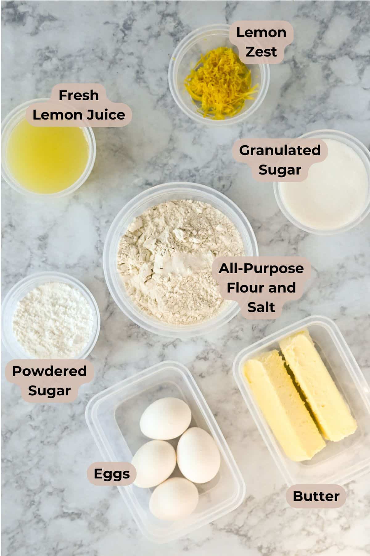 Labeled baking ingredients on a marble surface: eggs, butter, sugar, flour, salt, lemon zest, and lemon juice-everything you need to create delicious Tart Lemon Bars or zesty lemon cookies.