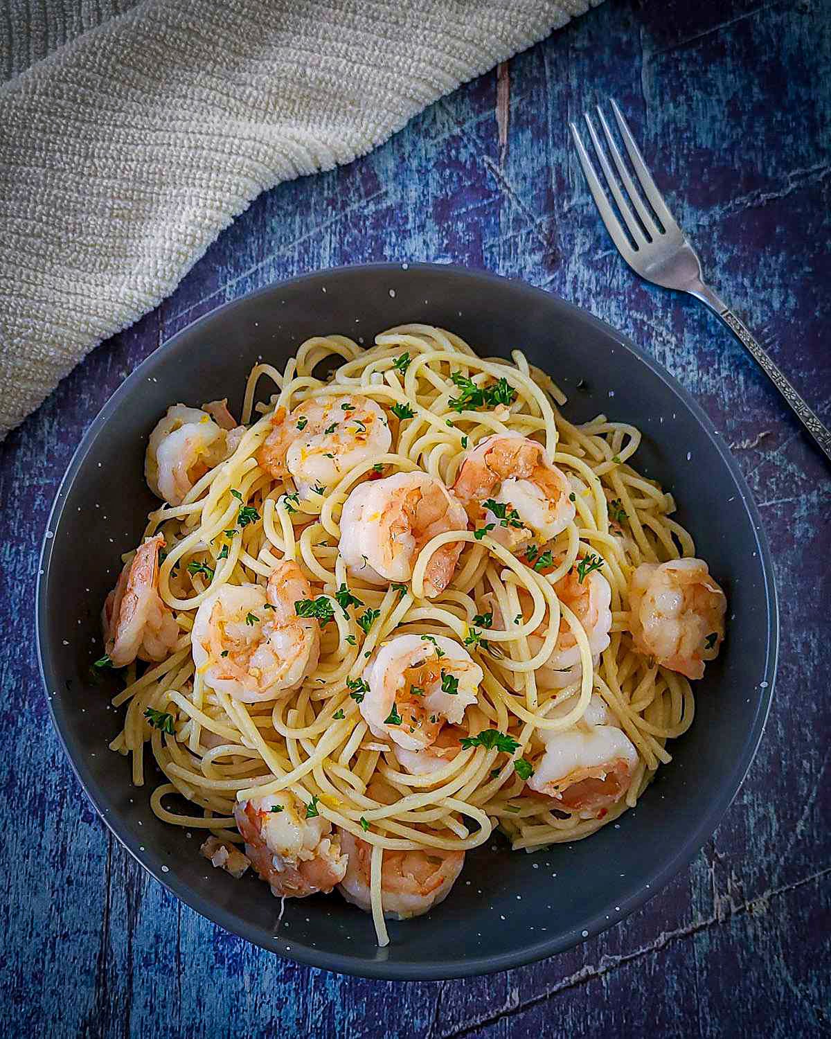 a bowl of spaghetti topped with shrimp