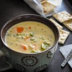 broccoli cheese soup in a bowl with crackers