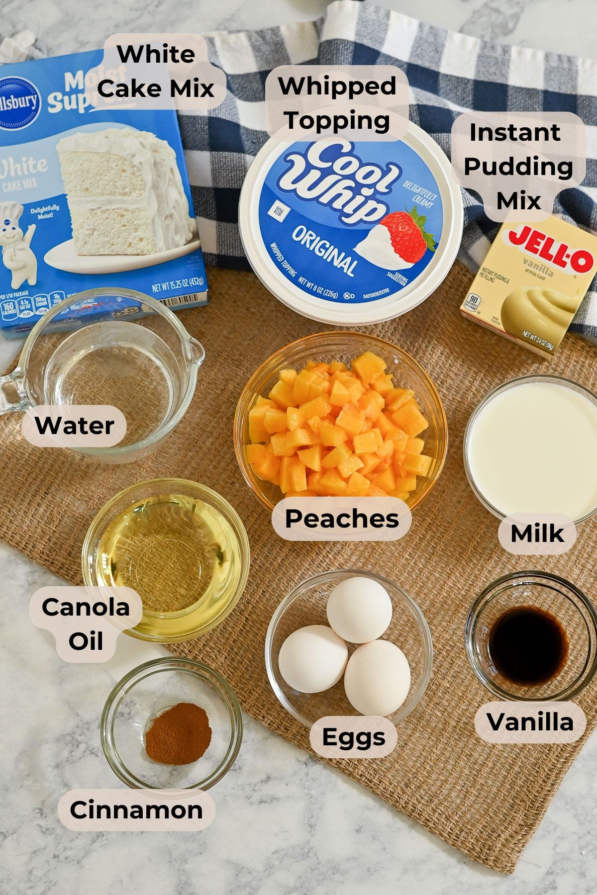 Pictured and labeled photo shows cake mix, whipped topping, pudding mix, peaches, eggs, milk, oil, and cinnamon.