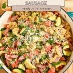 Large skillet filled with Pasta with Veggies & Smoked Sausage—rotini pasta, zucchini, smoked sausage, tomatoes, fresh parsley—all topped with cheese.