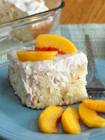 a slice of cake with peaches on a blue plate