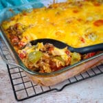 bell pepper casserole being served from a casserole dish with a black spoon
