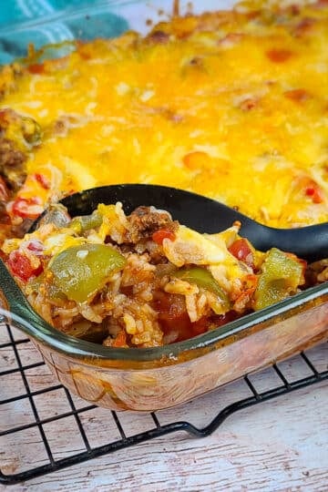 bell pepper casserole being served from a casserole dish with a black spoon
