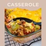 A Simple Bell Pepper Casserole in a glass dish with a serving spoon, filled with cheesy bell peppers and topped with perfectly melted cheese.