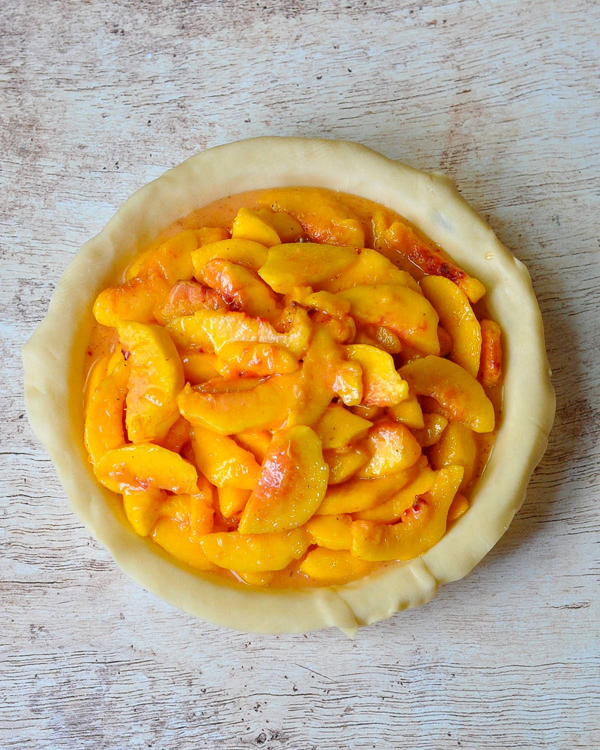 fresh peaches mixed with sugar and cornstarch in an unbaked pie shell