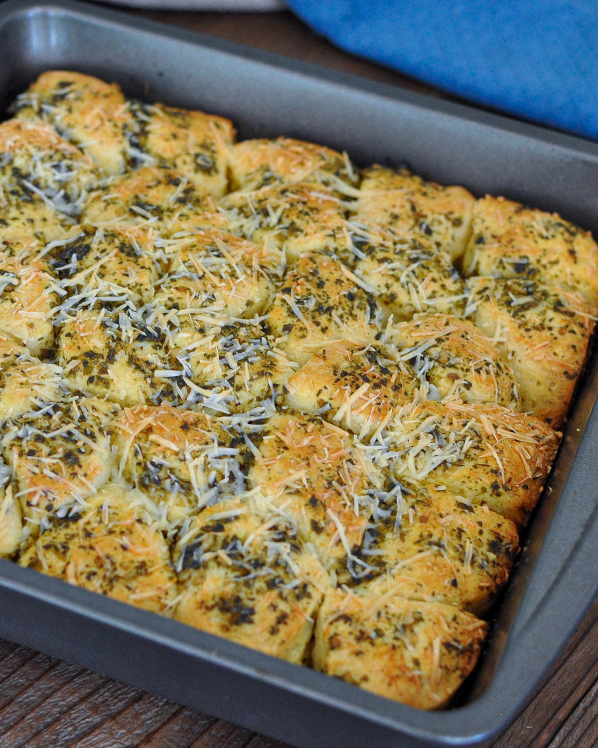 biscuits in a baking pan with pesto and parmesan. 