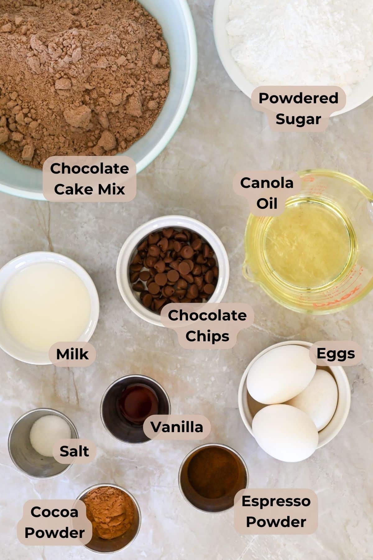 Bowls of chocolate cake mix, cocoa powder, chocolate chips, eggs, oil, milk, salt, vanilla, espresso, and powdered sugar-everything you need to create a decadent Chocolate Espresso Bundt Cake.