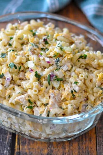macaroni salad with chicken in a clear glass bowl.