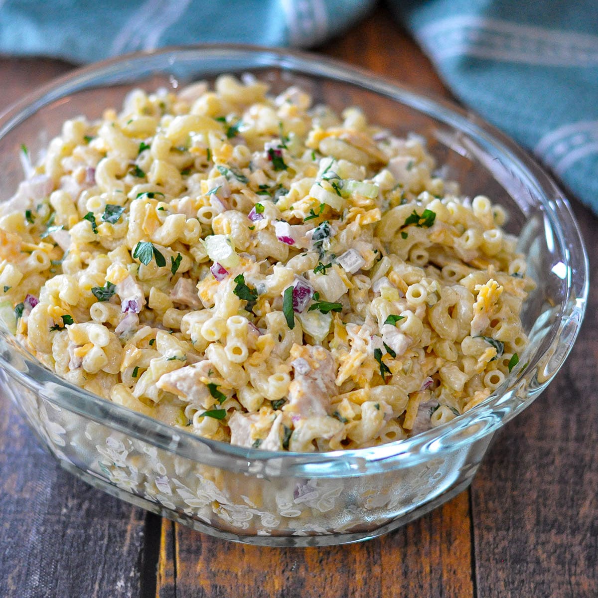 macaroni salad with chicken in a clear glass bowl.