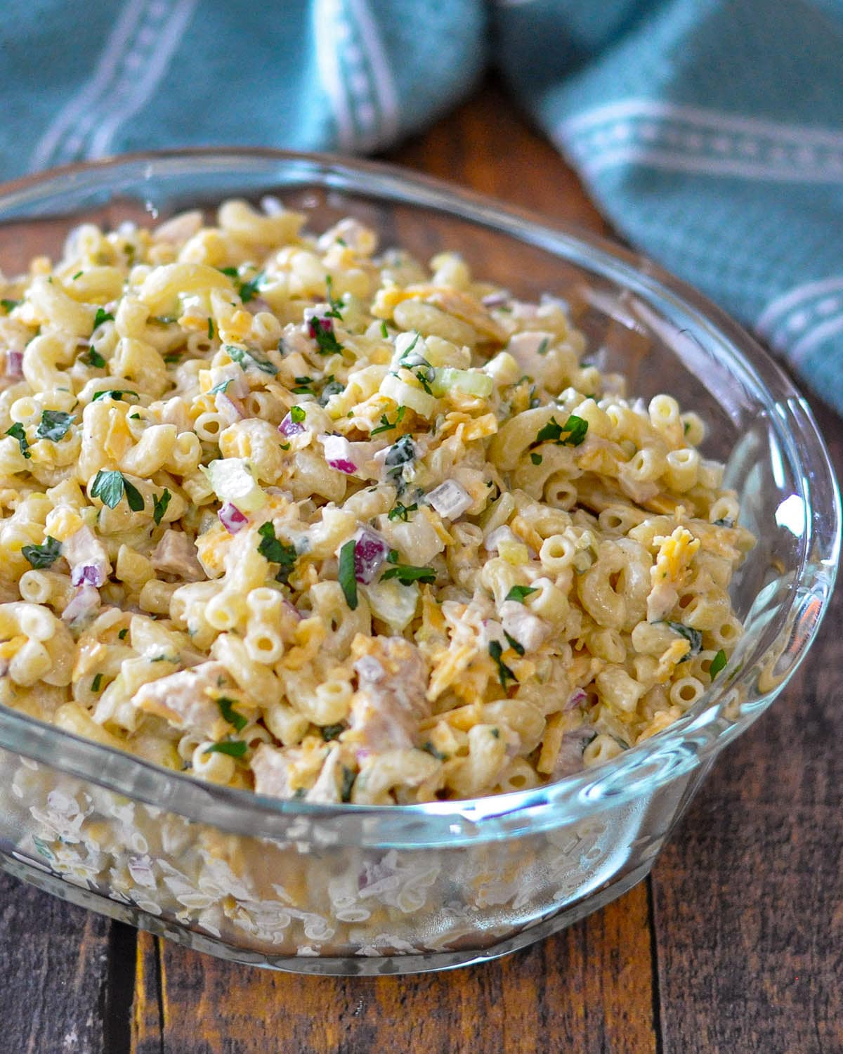 macaroni salad with chicken in a clear glass bowl. 