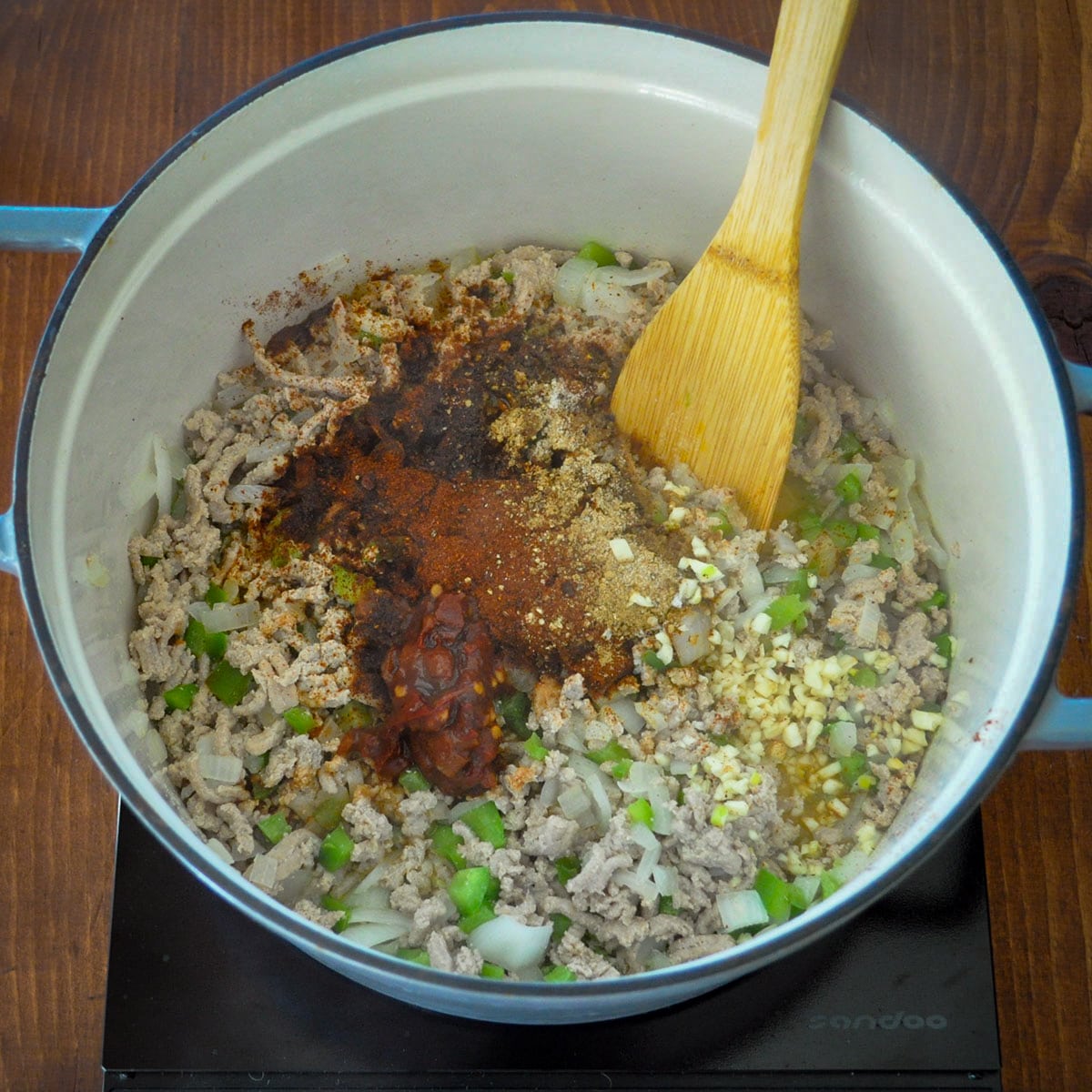 ground turkey being cooked in a large dutch oven with onions and spices. 