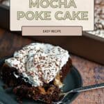 A slice of Chocolate Mocha Cake poke cake with whipped topping and chocolate shavings on a plate with a fork.