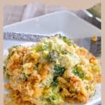A serving of Simple Broccoli Casserole with a cheesy, crunchy topping on a white plate, next to a fork.