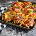 Baked sweet and sour chicken thighs on a sheet pan.