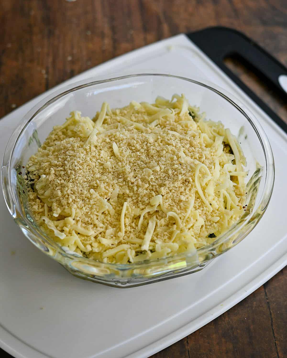 Shredded cheese and panko placed on top of zucchini and ready to bake.