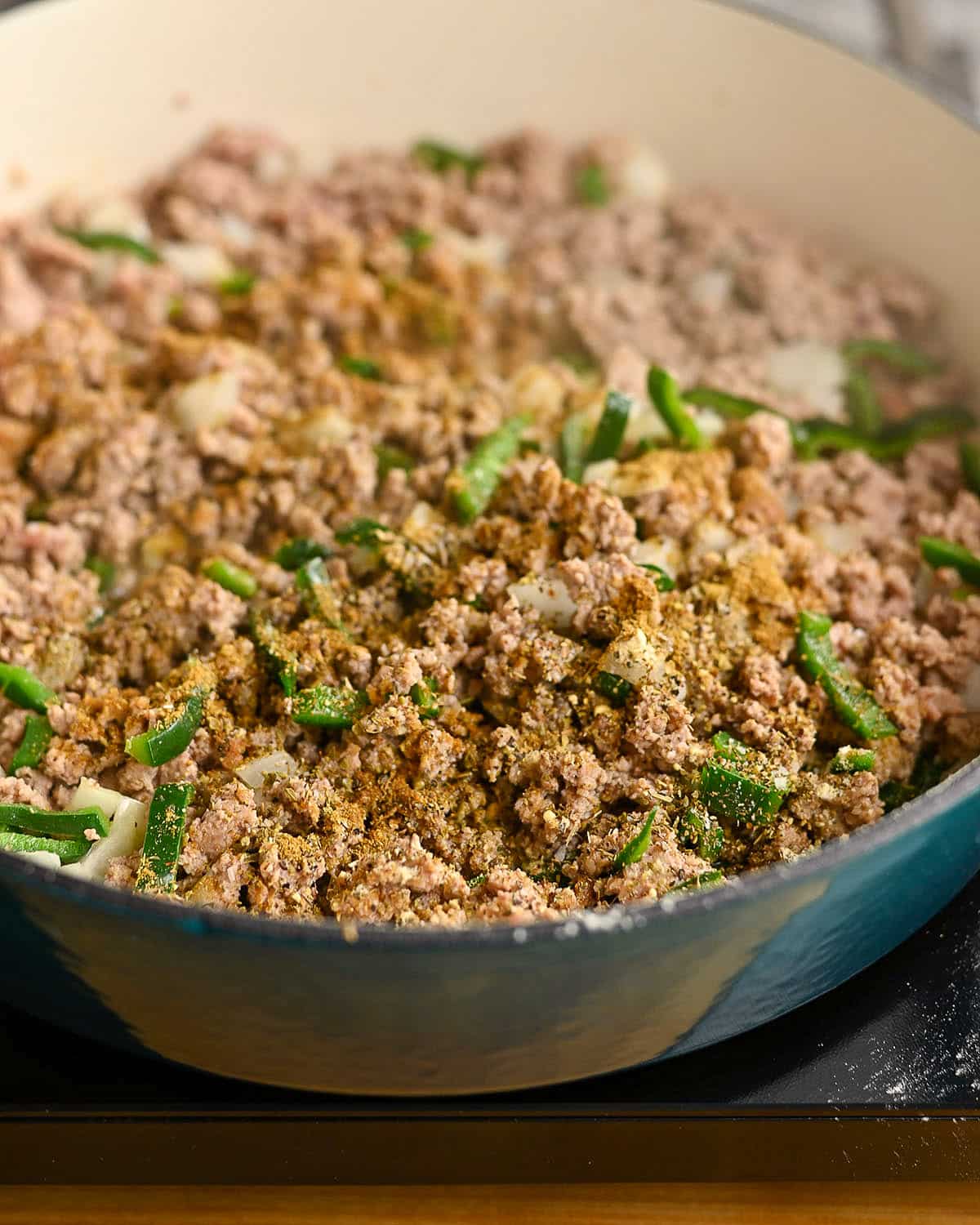 Seasoning added to ground turkey cooking in a skillet. 