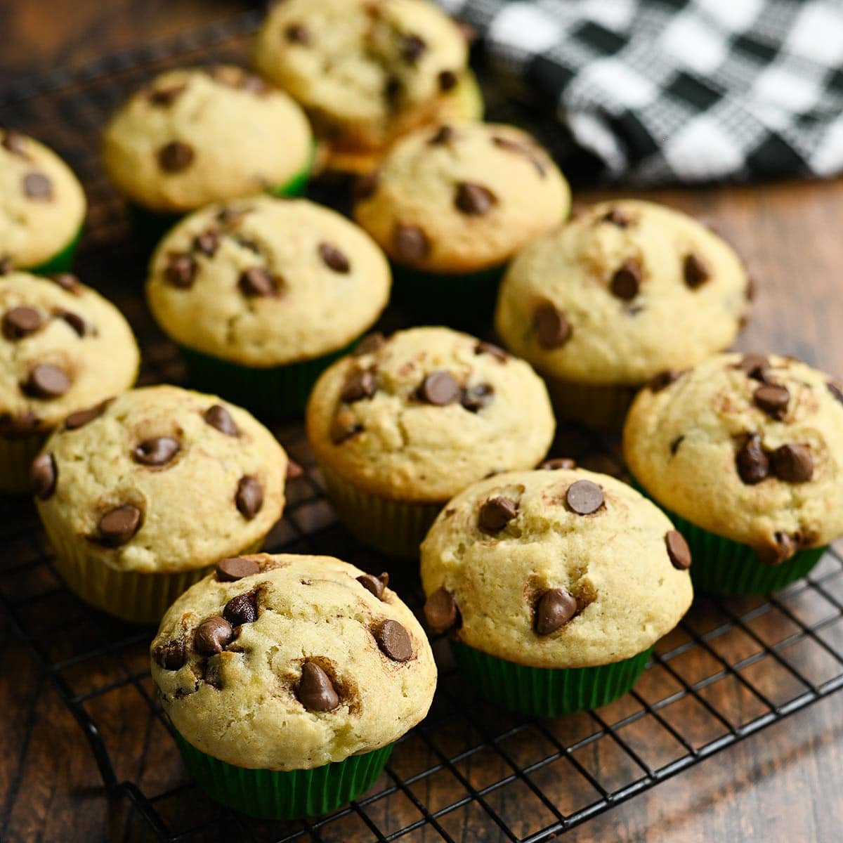 A closeup of a rack of muffins next to a black and white towel.