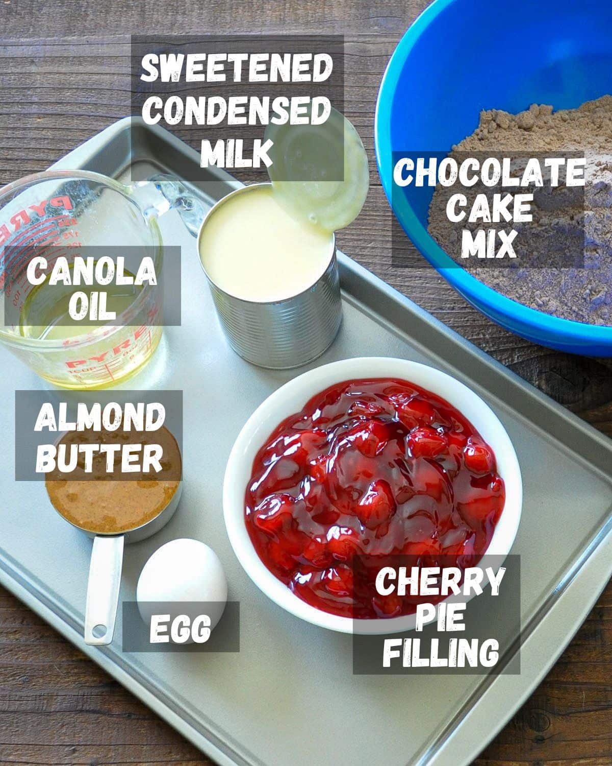 A labeled photo showing the ingredients for chocolate cherry cookie bars. 