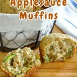 A basket of zucchini bread muffins with applesauce, including one sliced open to reveal its moist texture. Text overlay reads "Zucchini Applesauce Muffins.