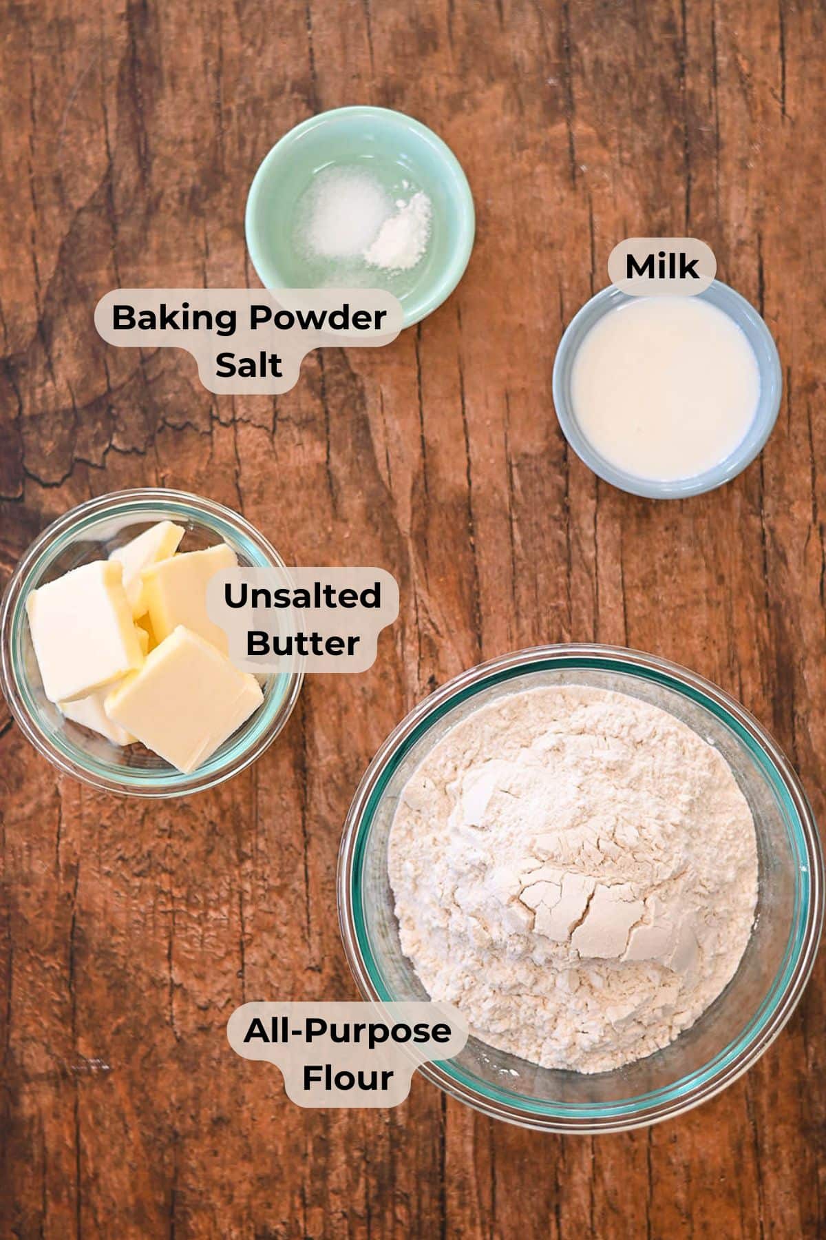 Buttery Pie Crust Four labeled bowls of baking ingredients for a classic Butter Pie Crust: baking powder and salt, milk, unsalted butter, and all-purpose flour.