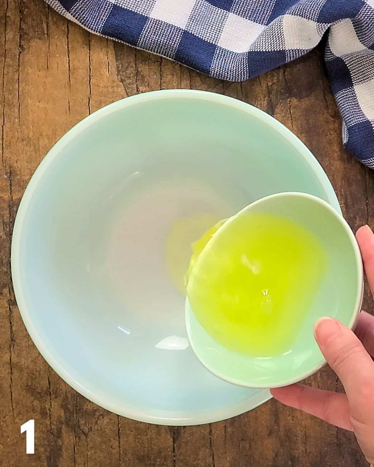 Egg whites being poured into a mixing bowl. 