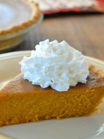 A slice of butternut pie on a cream colored plate.
