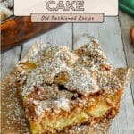 A slice of easy apple cake, dusted with powdered sugar, rests on brown parchment paper.