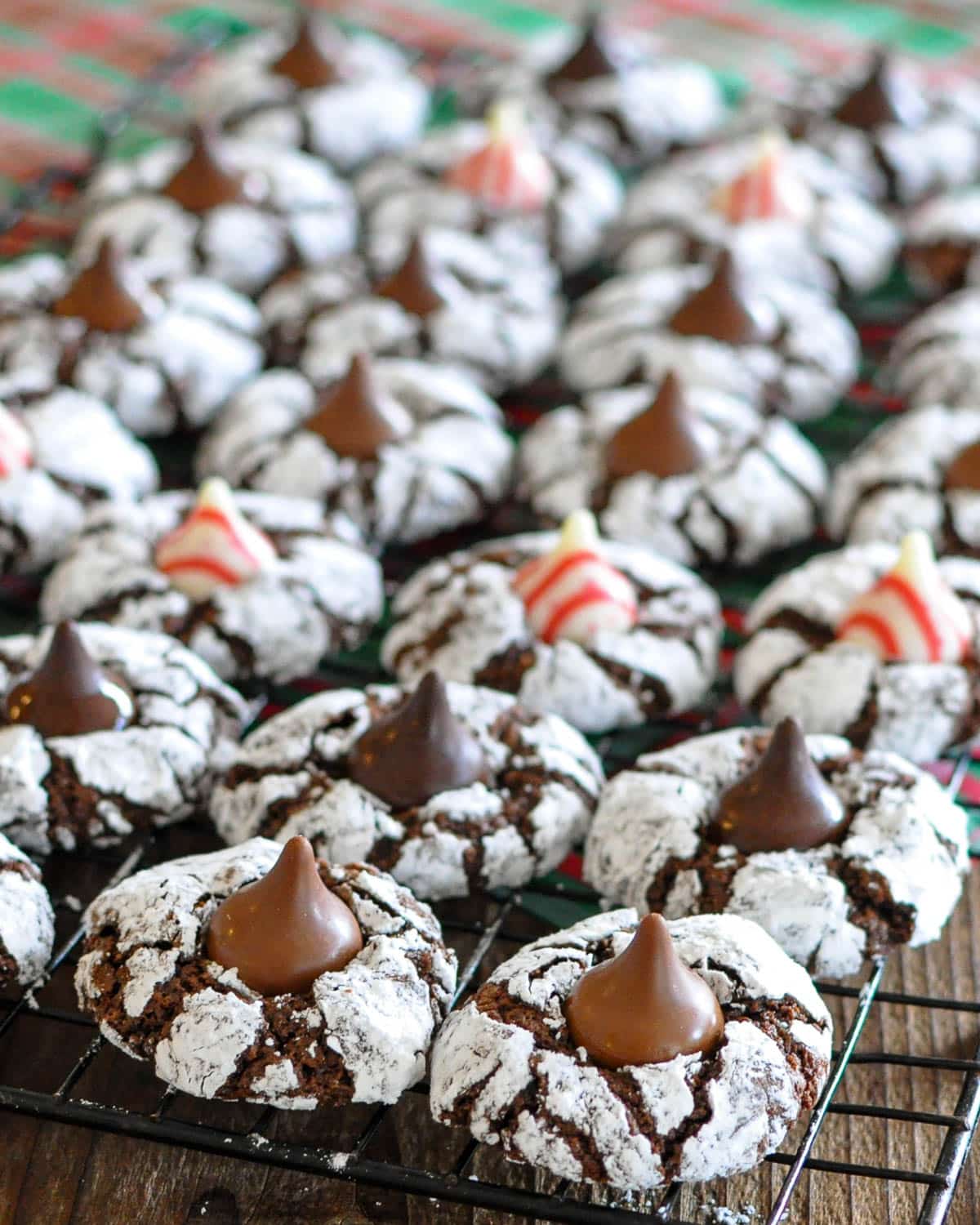 Chocolate crinkle cookies with a kiss on a cooling rack. 