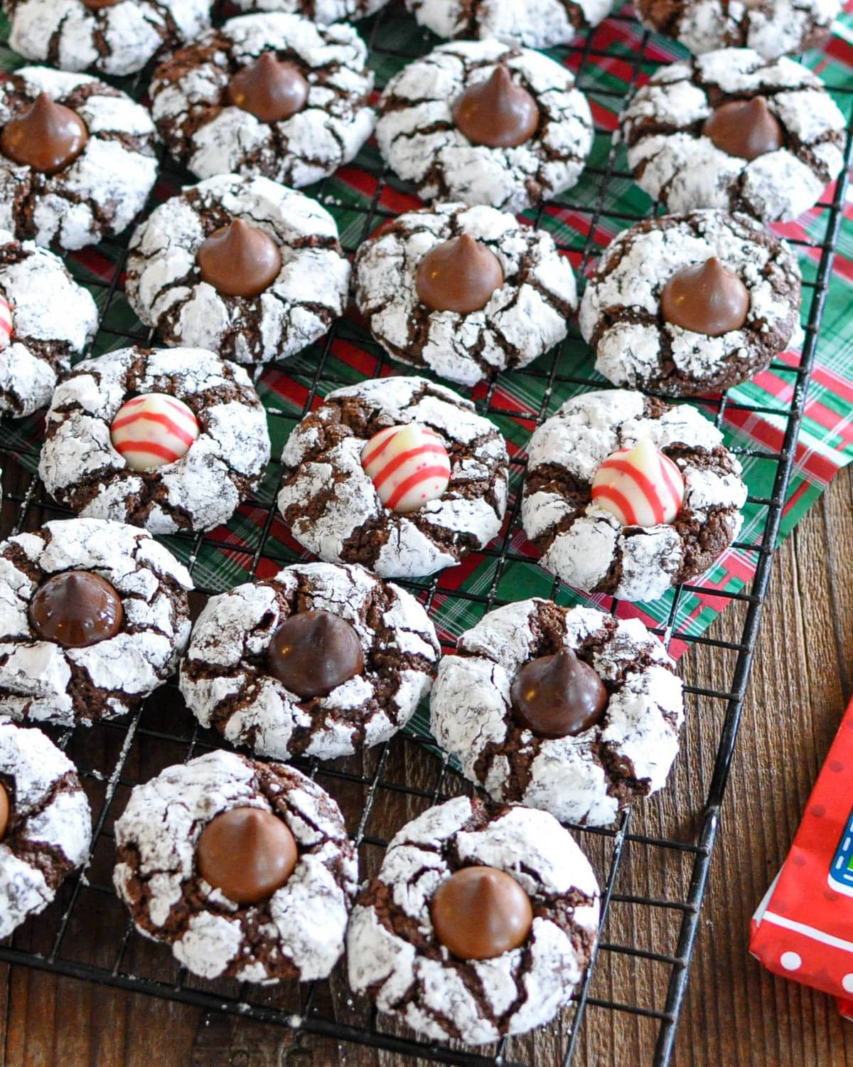 A cooling rack full of chocolate cookies with Hershey's kisses. 