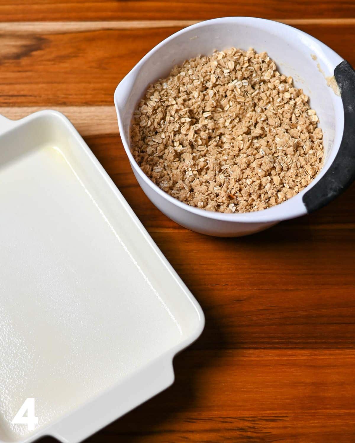 Mixed oatmeal crumble cookie base next to a prepared baking dish. 