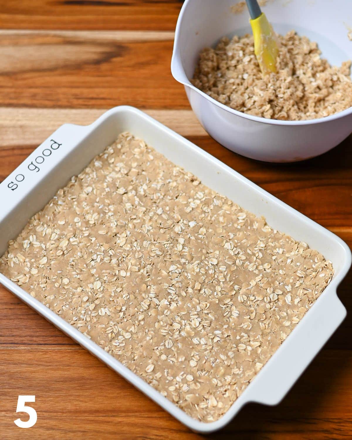 Oatmeal crumble cookie base pressed into a baking dish. 