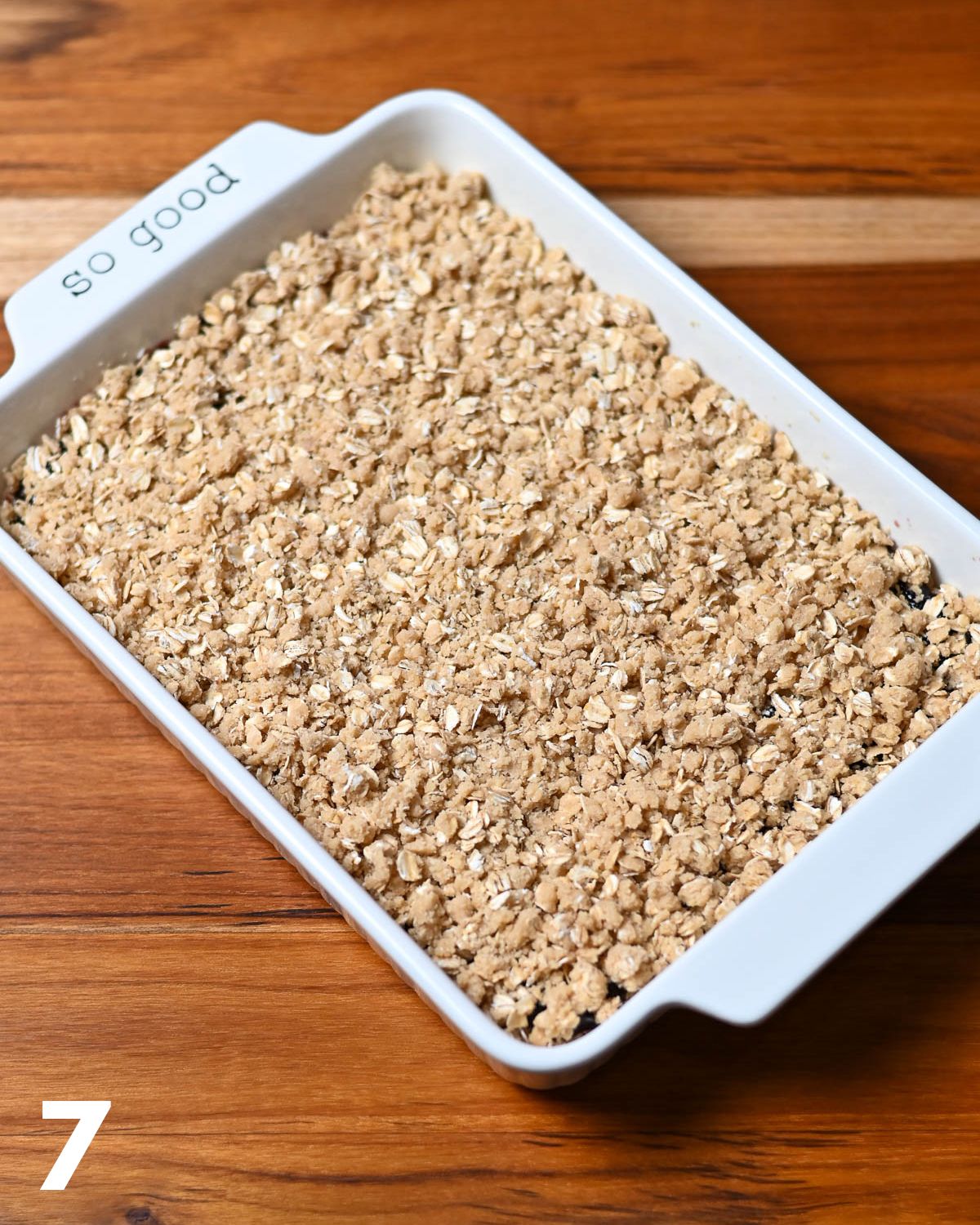 Oatmeal Jam Bars ready for the oven in a white baking dish. 