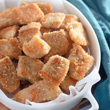 Golden brown catfish nuggets in a white bowl.