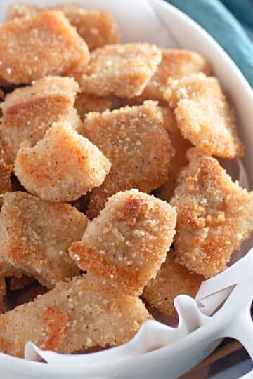 Golden brown catfish nuggets in a white bowl.