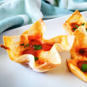 Pizza wonton cup appetizer on a white plate.