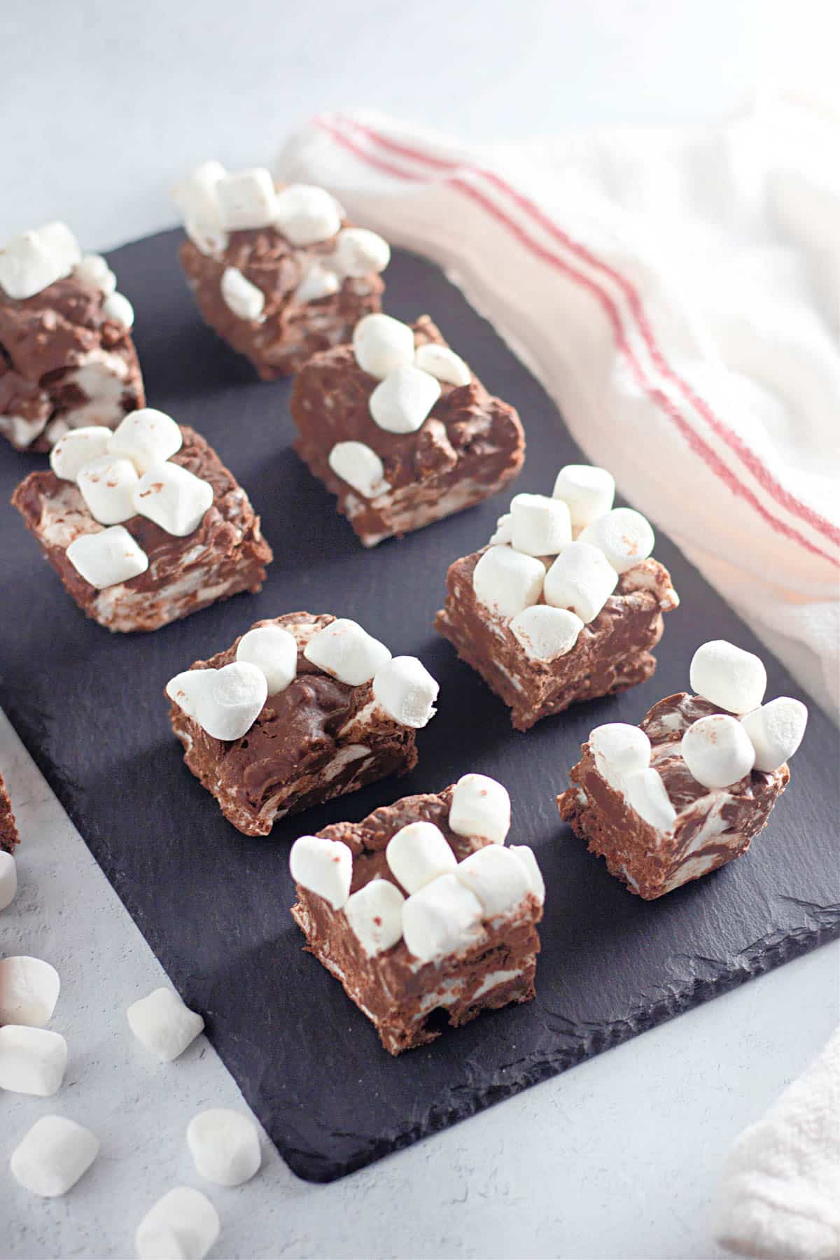 Squares of rocky road candy on black slate.