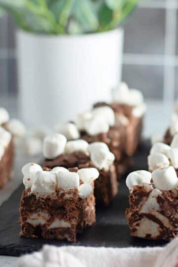 Squares of rocky road candy on black slate.