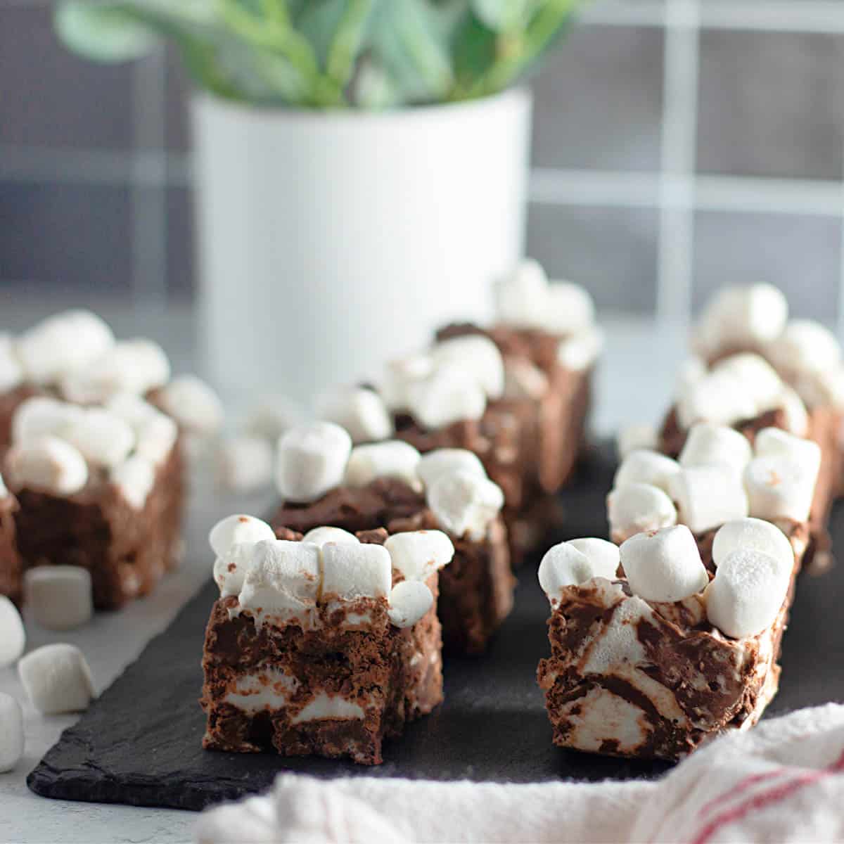 Squares of rocky road candy on black slate.