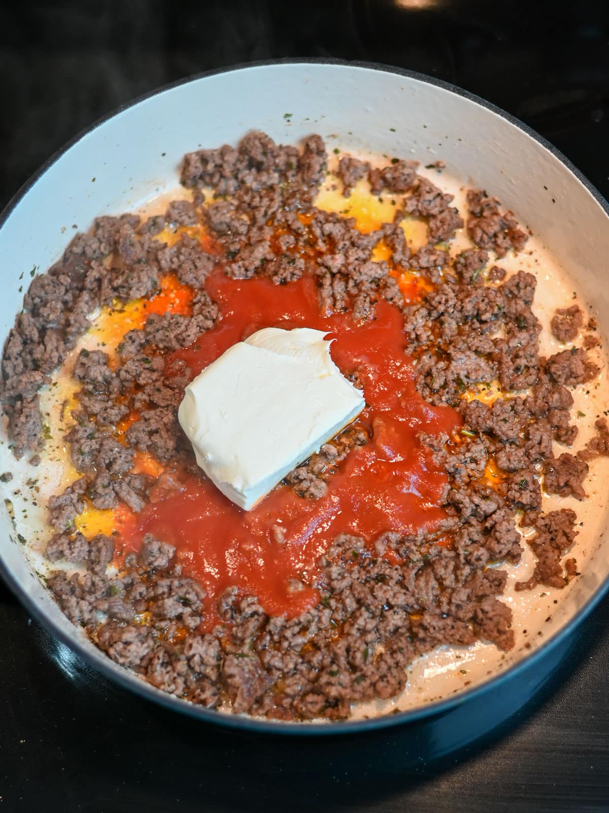 Tomato sauce and cream cheese added to browned ground beef. 