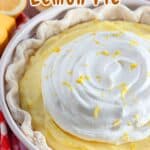 A lemon cream pie with whipped topping, garnished with lemon zest, sits on a red checkered cloth. Text reads "Sour Cream Lemon Pie".